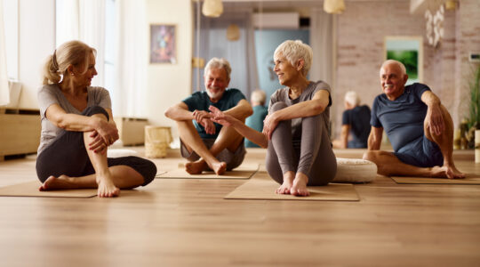 Ältere Paare sitzen entspannt in einer Gruppe auf Yogamatten – Tagesworkshop Achtsamkeit im Alltag für Paare